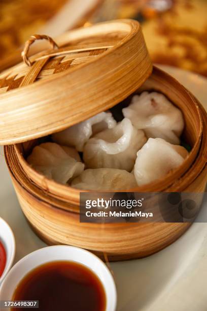 レストランのテーブルで竹のスチームバスケットに入った中国の点心餃子と醤油 - 点心 ストックフォトと画像
