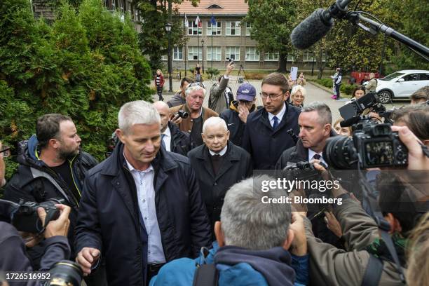 Jaroslaw Kaczynski, chairman of the Law and Justice party, center, leaves after voting in parliamentary elections at the election commission in...