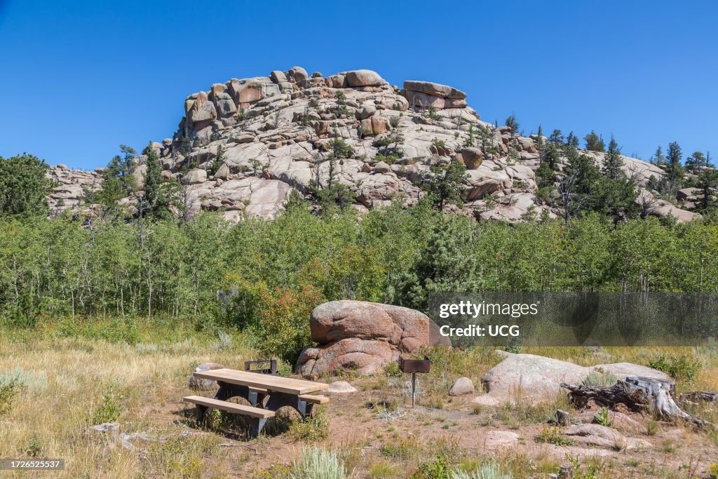 Granite rock outcropping behind a camp site with a picnic table, fire pit, and grill in the Vedauwoo Recreation Area of Medicine Bow National Forest in Wyoming
