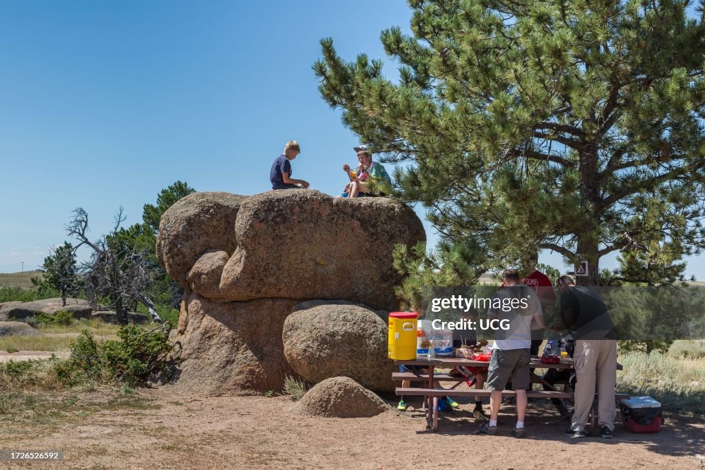 Family eating lunch and playing on large granite boulders in the Vedauwoo Recreation Area of Medicine Bow National Forest in Wyoming