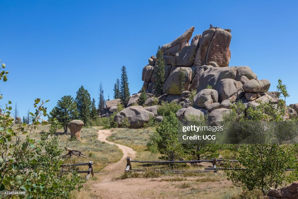 Men rock climbing on a large granite boulder in the Vedauwoo Recreation Area of Medicine Bow National Forest in Wyoming