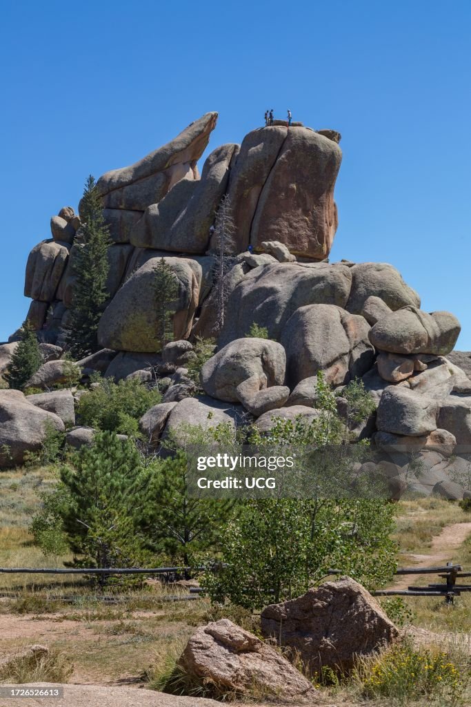 Men rock climbing on a large granite boulder in the Vedauwoo Recreation Area of Medicine Bow National Forest in Wyoming