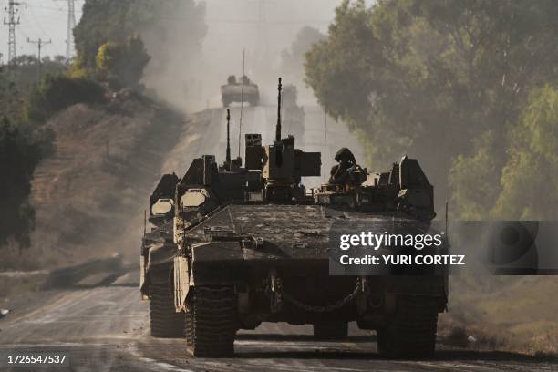 Israeli army armoured vehicles roll towards the border with the Gaza Strip at an undisclosed location in southern Israel on October 15, 2023....