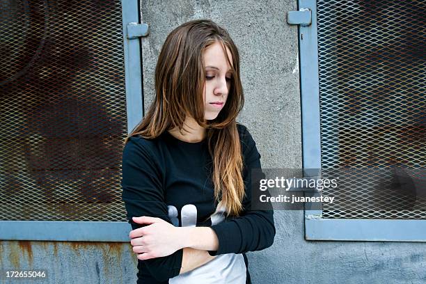 a sad teenager girl crossing her arms - homeless child stock pictures, royalty-free photos & images