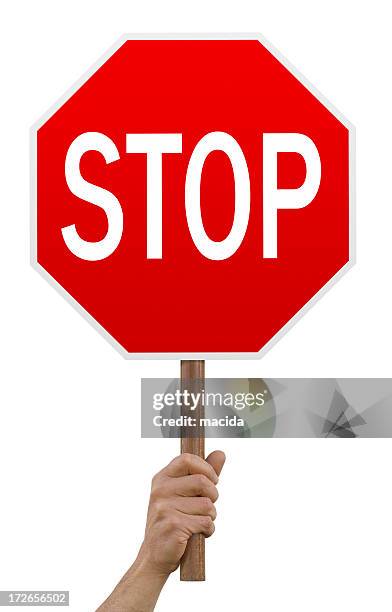 hand holding up red octagonal stop sign - sign stockfoto's en -beelden