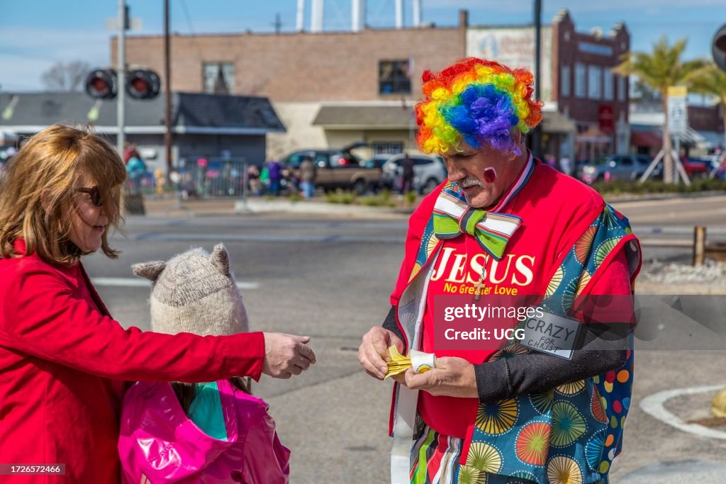 Man dressed as clown handing out Christian evangelistic materials at Mardi gras parade in downtown Gulfport, Mississippi