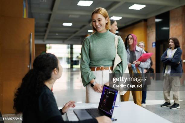 woman getting her id checked before going for a lecture in a conference - exposição imagens e fotografias de stock