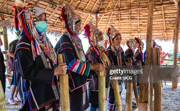 Elderly traditionally dressed people perform a musical chant for a fee in the Akha tribe area of the Union of Hill Tribe Villages outside of Chiang...