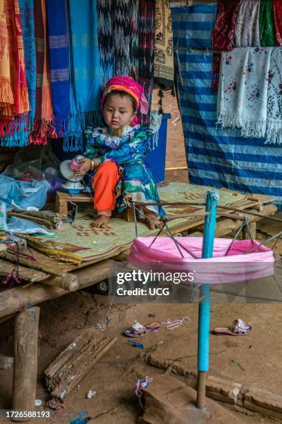 Tribal child spooling yarn for weaving scarves to be sold in the Long Neck Karen tribe area of the Union of Hill Tribe Villages outside of Chiang Rai...