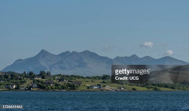 Isle of Skye, Scotland, UK, Panoramic view of the Cuillin mountains across green countryside and residential homes on the Isle of Skye.