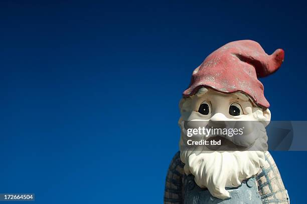 garden gnome with red hat on a blue background - garden gnome stock pictures, royalty-free photos & images