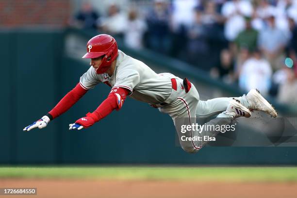 Trea Turner of the Philadelphia Phillies slides into second base after hitting a double in the first inning against the Atlanta Braves during Game...