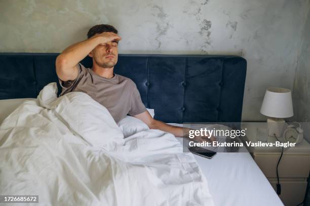 man in bed with headache - krankenbett stock-fotos und bilder