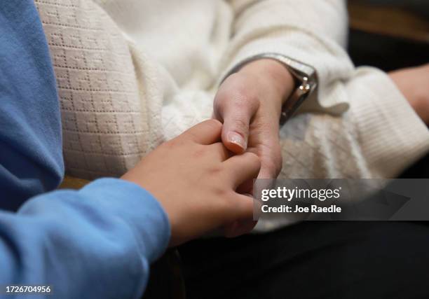 Mother and daughter hold hands during a vigil at the Washington Hebrew Congregation for Israel on October 09, 2023 in Washington, DC. The vigil was...