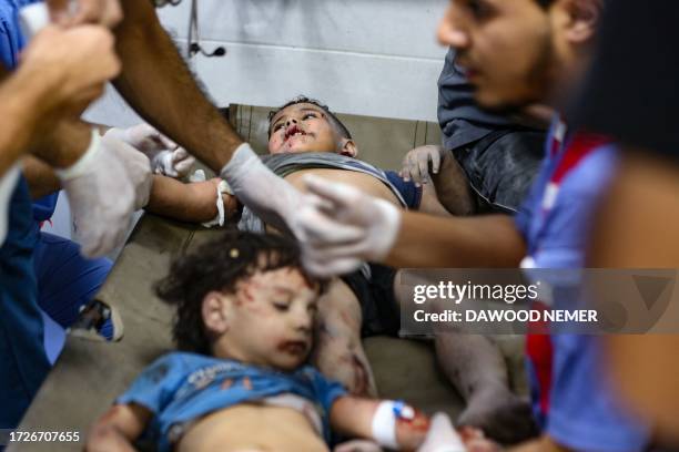 Children injured in an Israeli strike receive emergency medical care at the Al-Shifa hospital in Gaza City on October 15, 2023. Israel embarked on a...