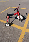 Red Tricycle with white wheels on playground