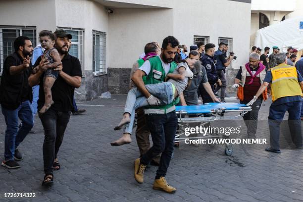 Children injured in an Israeli strike are rushed to the Al-Shifa hospital in Gaza City on October 15, 2023. Israel embarked on a withering air...