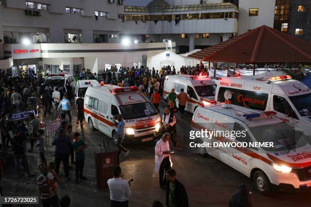 Ambulances carrying victims of Israeli strikes crowd the entrance to the emergency ward of the Al-Shifa hospital in Gaza City on October 15, 2023....