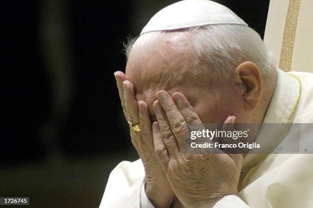 Pope John Paul II holds his hands to his face as he attends his weekly general audience January 15, 2003 in Vatican City, Italy. Despite his frail...