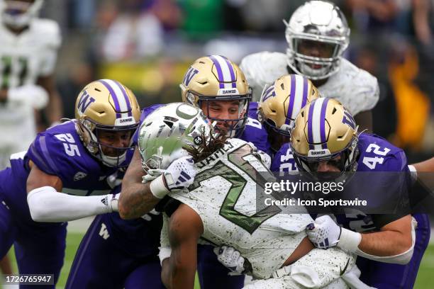 Washington defensive players Elijah Jackson, #8 Bralen Trice and Carson Bruener stuff Oregon Jordan James at the line of scrimmage during the college...