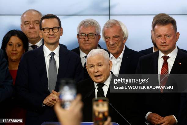 Polish Deputy Prime Minister and leader of the Law and Justice party party, Jaroslaw Kaczynski stands next to Polish Prime Minister Mateusz...