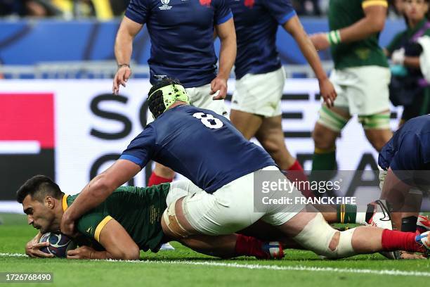 South Africa's inside centre Damian de Allende scores a try ahead of France's number eight Gregory Alldritt during the France 2023 Rugby World Cup...