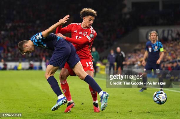 Croatia's Josip Stanisic and Wales' Ethan Ampadu battle for the ball during the UEFA Euro 2024 Qualifying Group D match at the Cardiff City Stadium,...