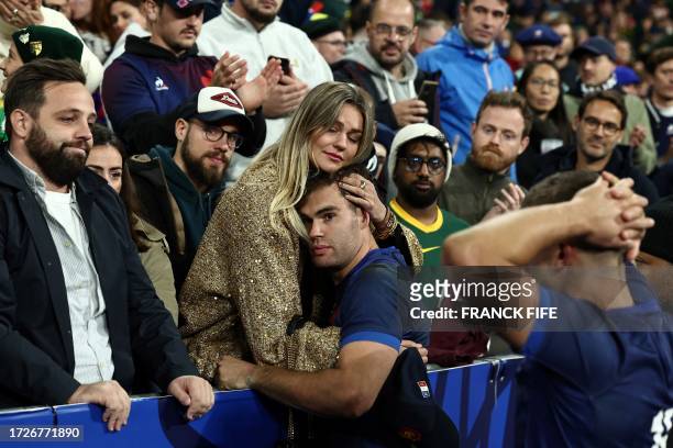 France's wing Damian Penaud is embraced by girlfriend Morgan Vernet after defeat in the France 2023 Rugby World Cup quarter-final match between...