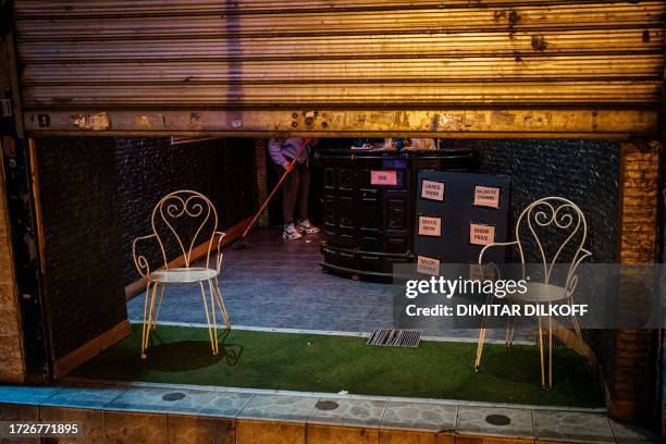Woman cleans a floor of an erotic theatre near Place Pigalle at night in Paris on October 15, 2023.
