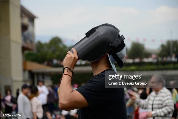 October 14 Mexico City, Mexico: A man watches the Annular Solar Eclipse with a welding mask at the National Autonomous University of Mexico .