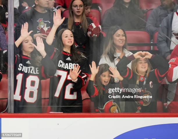 Fans of the Ottawa Senators bang on the glass trying to get the attention of players during warmup prior to a game against the Tampa Bay Lightning at...