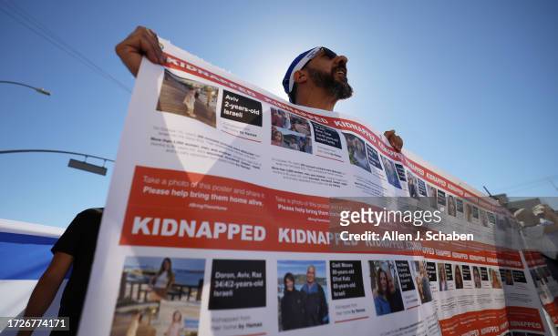 Bill Hillel of Woodland Hills holds up a kidnap poster while participating in a solidarity march for Israel starting at the Young Israel of Century...