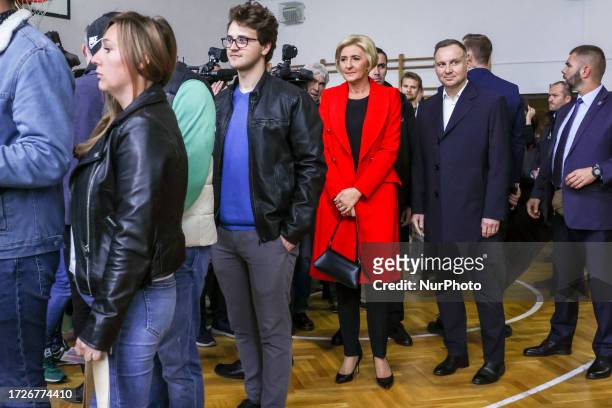 Andrzej Duda, the President of Poland, and his wife, Agata Kornhauser-Duda, wait in a line to cast their ballots at a polling station in Polish...