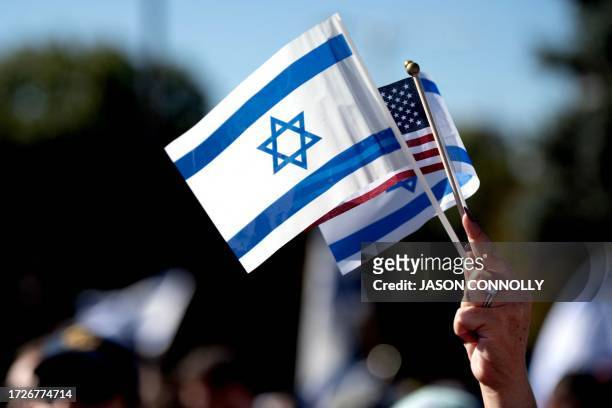 Demonstrator holds up the flags of Israel and the United States during a rally in support of Israel outside the Colorado State Capitol Building in...