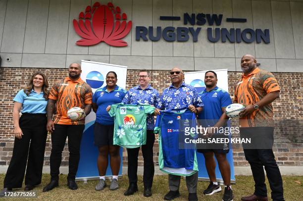 Fiji's Prime Minister Sitiveni Rabuka and Pat Conroy , Australia's Minister for International Development and the Pacific, pose with rugby players...