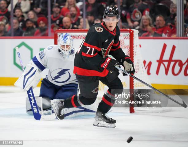 Ridly Greig of the Ottawa Senators chases the puck in front of Matt Tomkins of the Tampa Bay Lightning at Canadian Tire Centre on October 15, 2023 in...