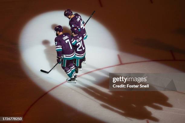 Cam Fowler and Radko Gudas of the Anaheim Ducks help introduce this year's 21st Duck, Trent Sullivan, prior to the game against the Carolina...