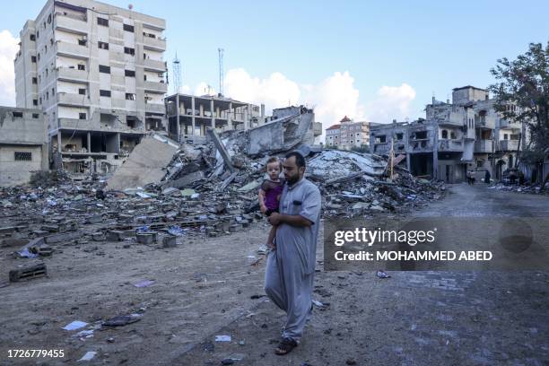 Palestinian man walks amid the rubble of buildings destroyed during Israeli air strikes in the Rafah refugee camp in the southern of Gaza Strip, on...