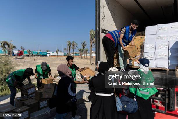 Volunteers load food and supplies onto trucks in an aid convoy for Gaza on October 16, 2023 in North Sinai, Egypt. The aid convoy, organized by a...