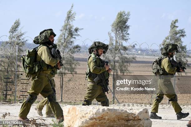 Israeli soldiers patrol in southern Israel in front of fences on the border with the Gaza Strip on Oct. 15, 2023.