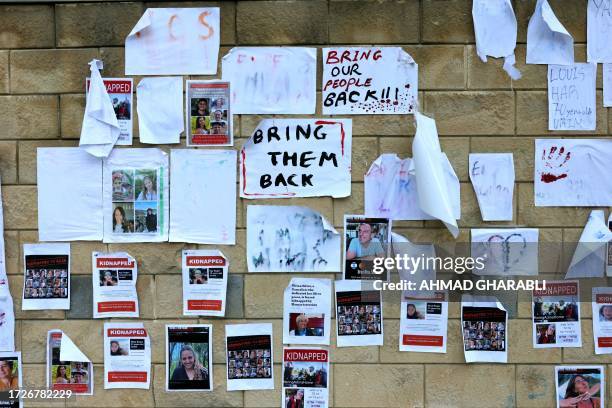 Images of Israeli hostages snatched by the Palestinian militant group Hamas last week in a surprise attack into Israel, are plastered on a wall...