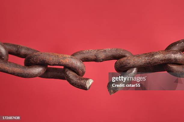 chain with broken link on red background - broken shackles stock pictures, royalty-free photos & images