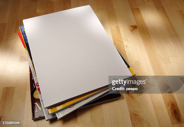 stack of magazine on a table - coffee table stockfoto's en -beelden