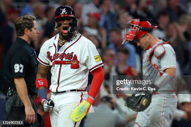 Ronald Acuna Jr. #13 of the Atlanta Braves reacts after scoring on a two-run home run by Austin Riley in the eighth inning against the Philadelphia...