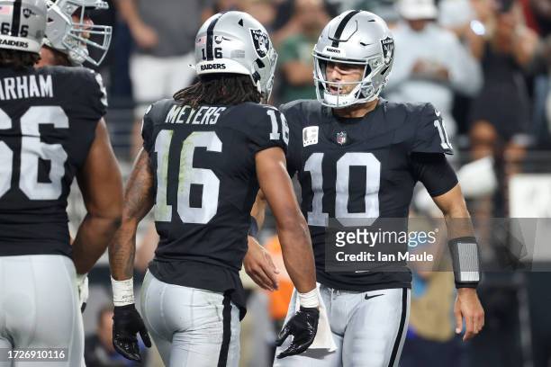 Jakobi Meyers of the Las Vegas Raiders celebrates his touchdown catch with Jimmy Garoppolo during the second quarter against the Green Bay Packers at...