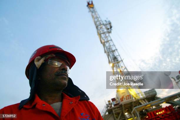 An oil worker walks past a ChevronTexaco drilling platform January 15, 2003 near the Saudi Arabian border, Kuwait. Kuwait produces 10% of the worlds...