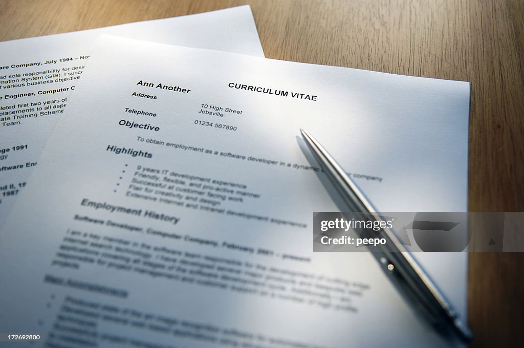 Selective focus shot of a resume and pen