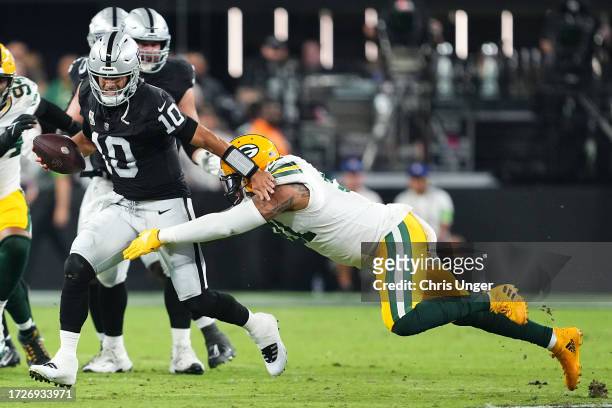 Jimmy Garoppolo of the Las Vegas Raiders runs the ball against Preston Smith of the Green Bay Packers during the first half at Allegiant Stadium on...