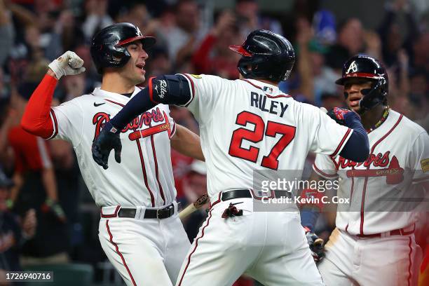Austin Riley celebrates with Matt Olson and Ronald Acuna Jr. #13 of the Atlanta Braves after hitting a two-run home run in the eighth inning against...