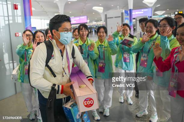Volunteers send gifts to head of the Hong Kong delegation Kenneth Fok Kai-kong at Hangzhou Xiaoshan International Airport on October 9, 2023 in...